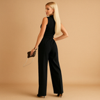 Women’s elegant wrap jumpsuit with tailored waist and wide-leg design, available in white, black, khaki, and pink. Ideal for business, formal, and stylish occasions.