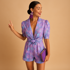 Women’s short summer jumpsuit with vibrant print and waist belt, available in pink and purple, perfect for warm days and summer outings.